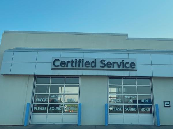 Exterior of an auto service center with "Certified Service" sign above entrance.