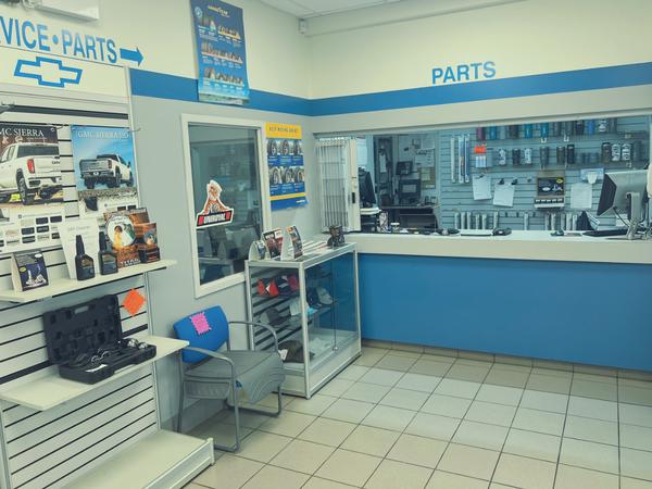 Auto parts store interior with service counter, brochures, and product displays on shelves.