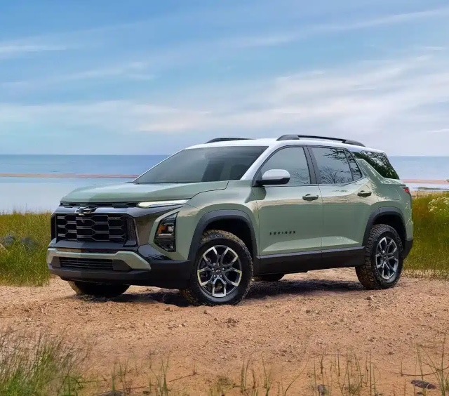 SUV parked on a sandy beach with a scenic sea and sky backdrop, showcasing its modern design.